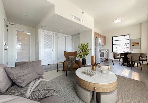 A modern living room with a grey couch and a round coffee table.